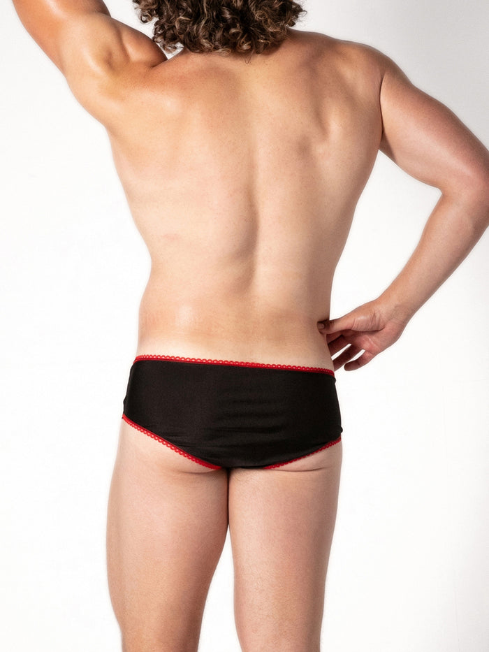 Person wearing black underwear with red trim on a white background