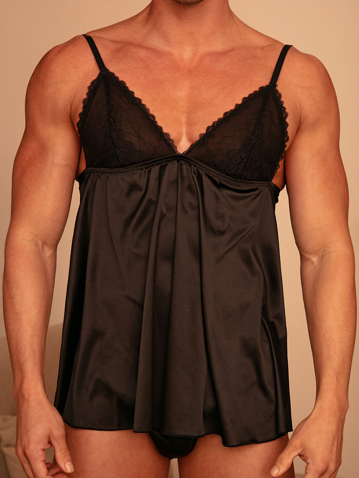 Front view of a man wearing a black satin babydoll with matching underwear.