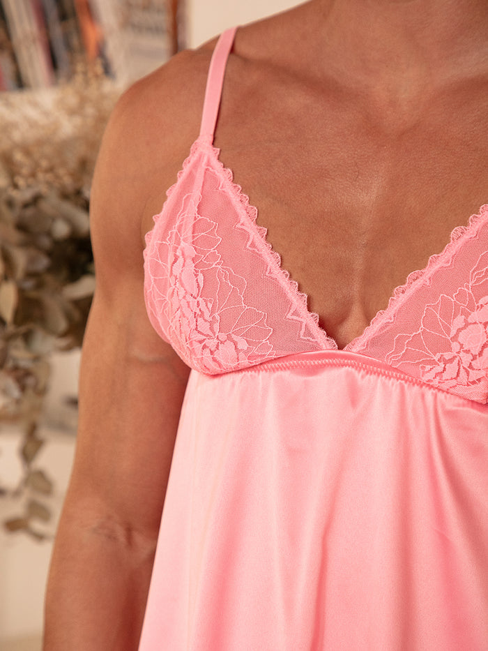 Closeup view of a man wearing a pink babydoll with lace cups.