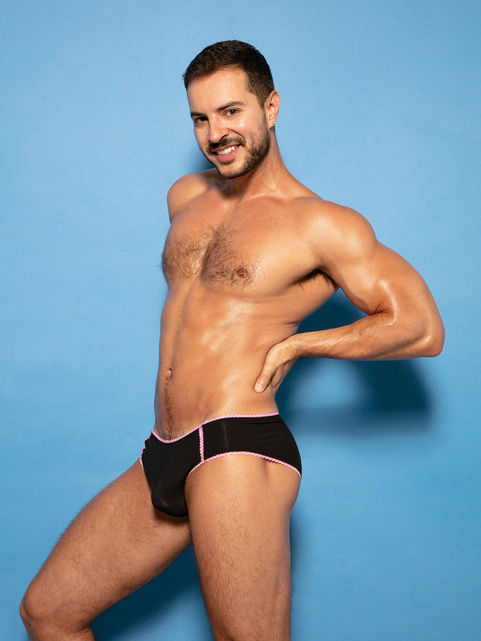 Man wearing black XDress panties with pink lace trim.