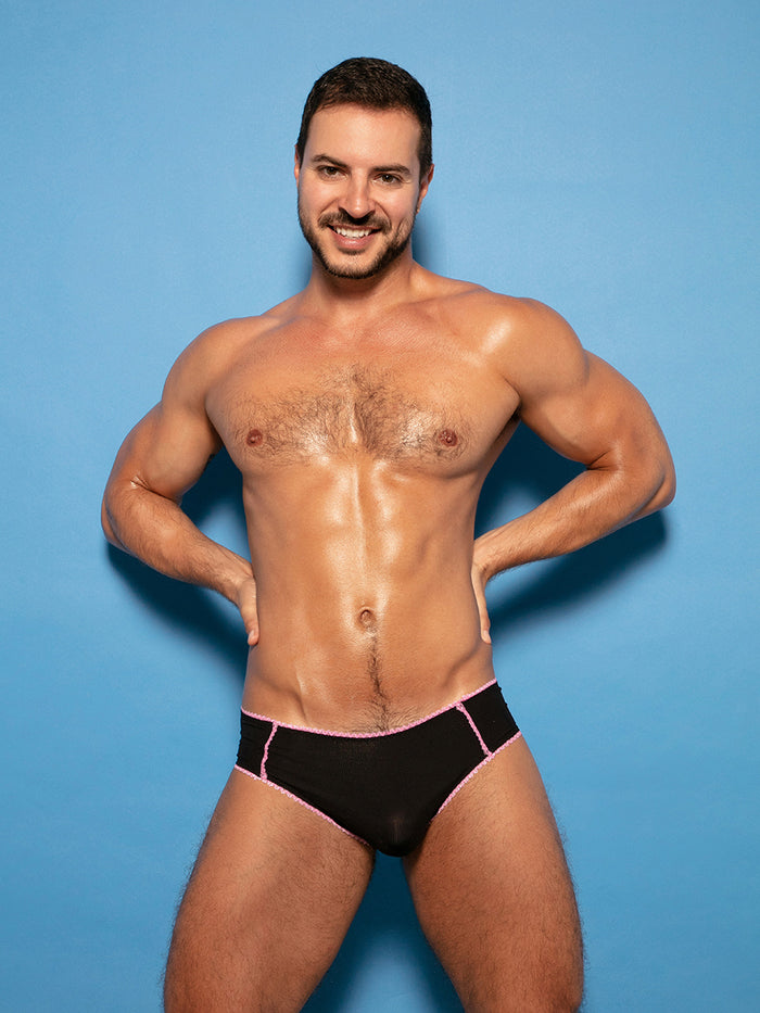 Man wearing black XDress panties with pink lace trim.