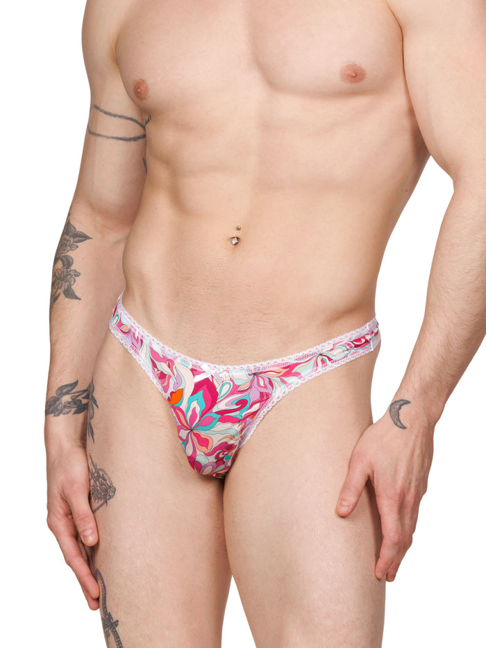 Front view of a male model wearing a pink floral thong panty with white lace trim