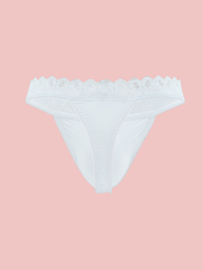White lace trimmed thong panty on a pink background.